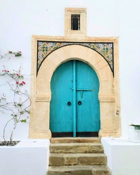 Porte turquoise avec décorations anciennes.