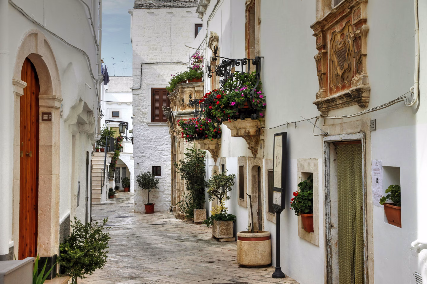 Road trip dans les Pouilles : mon itinéraire de 7 jours en solo 9 Rue pittoresque avec fleurs colorées Ostuni la cité blanche Italie les pouilles